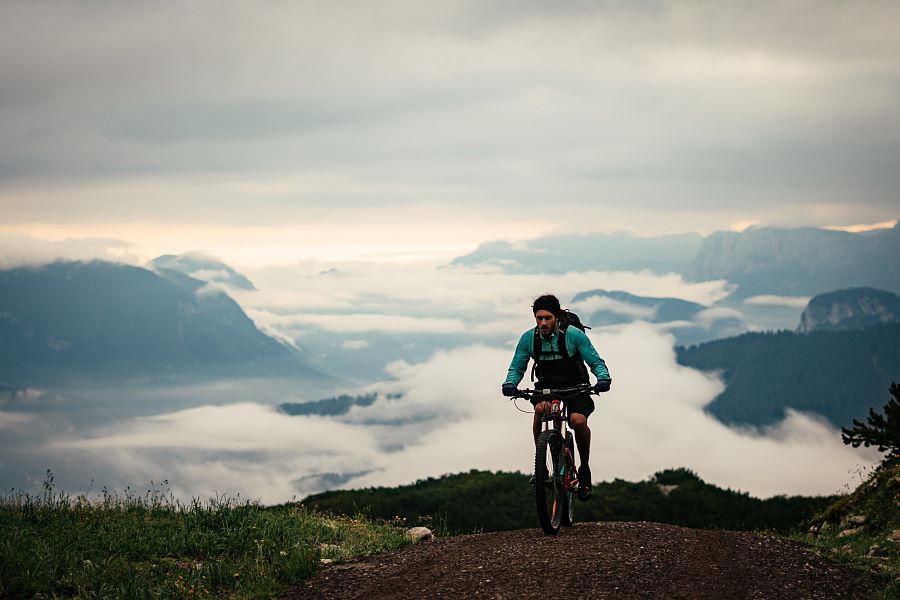 Kitzbüheler Alpen Bike Hero Ben Kalra am Weg zum Gipfel und das PillerseeTal onder een mistdeken c Daniel Gollner