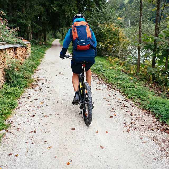 Kitzbüheler Alpen Hero Bike Patrick Ager fährt über eine Schotterstraße neben der Ache nach Wörgl c Daniel Gollner