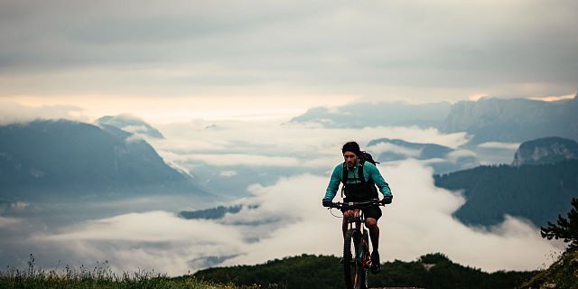 Kitzbüheler Alpen Bike Hero Ben Kalra op weg naar de top; het PillerseeTal ligt onder de wolken c Daniel Gollner