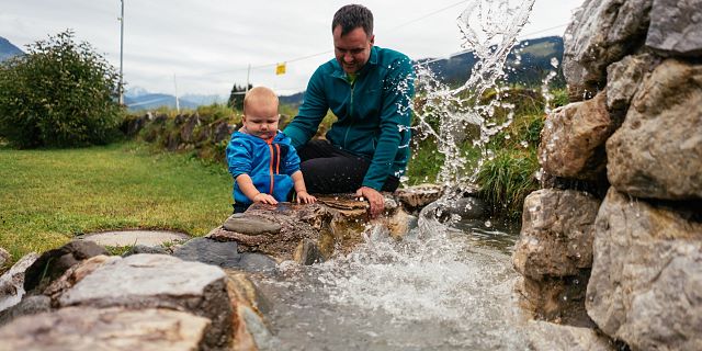 Kitzbüheler Alpen Hero Familie O´Brien zoon speelt met zijn vader met het water in de Kneippinrichting in Aschau c Daniel Gollner